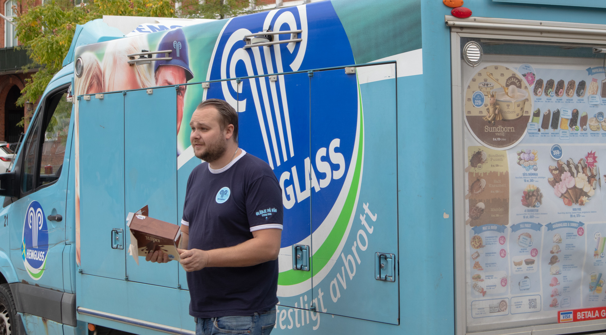 Glassbil man som delar ut glass med en blå glassbil bakgrunden
